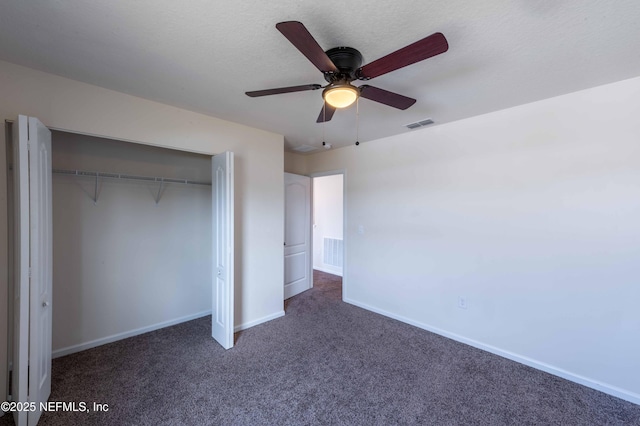 unfurnished bedroom featuring dark carpet, a textured ceiling, a closet, and ceiling fan