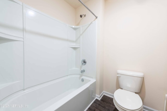 bathroom featuring wood-type flooring, shower / bathtub combination, and toilet