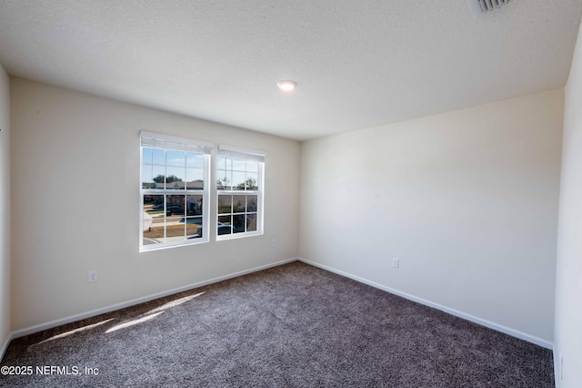 carpeted spare room featuring a textured ceiling