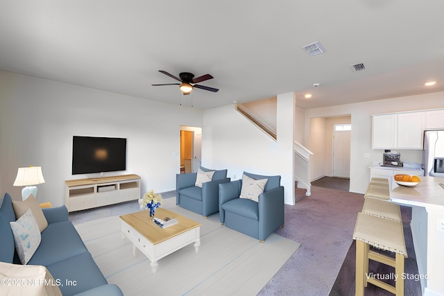 carpeted living room with ceiling fan