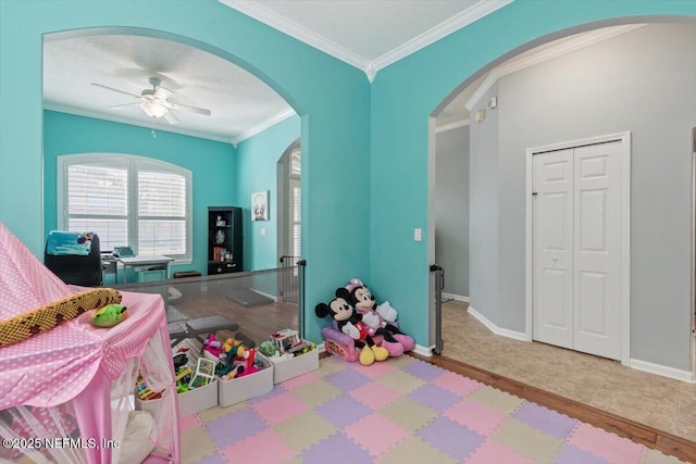 rec room featuring crown molding, a textured ceiling, and ceiling fan