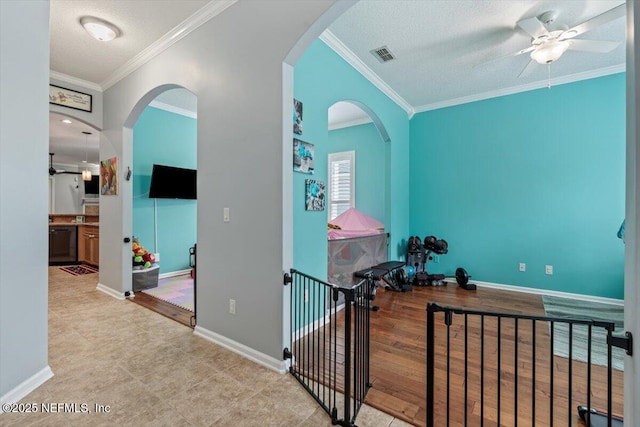 corridor with ornamental molding and a textured ceiling