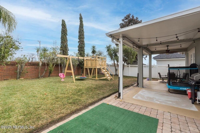 view of yard with a playground, ceiling fan, and a patio area