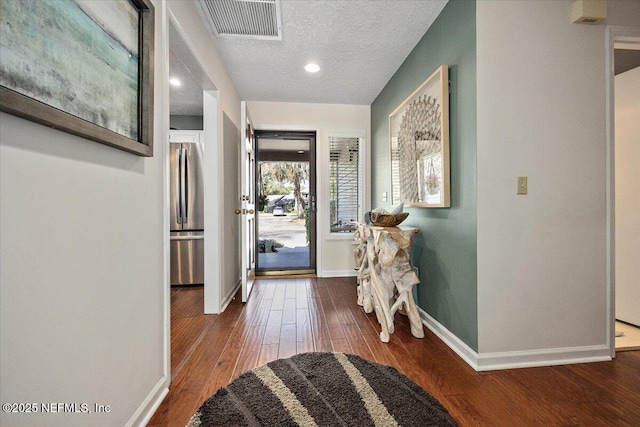 entrance foyer featuring a textured ceiling and dark hardwood / wood-style flooring