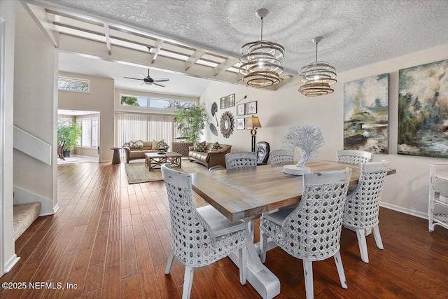 dining room featuring beam ceiling, dark hardwood / wood-style floors, ceiling fan with notable chandelier, and a textured ceiling