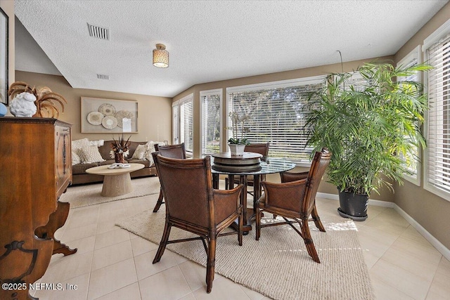 tiled dining room featuring a textured ceiling