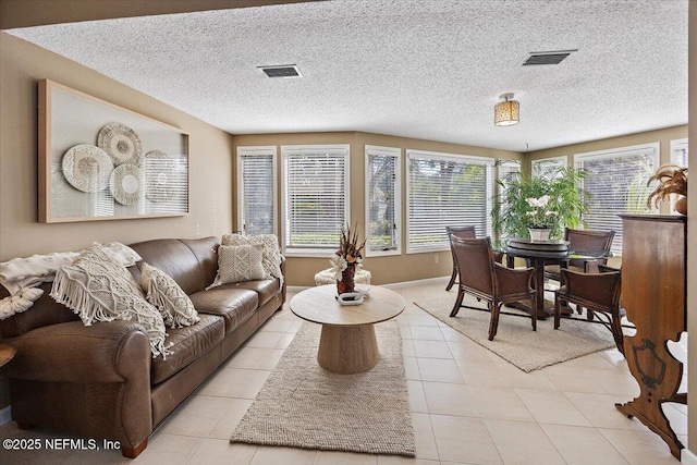 tiled living room featuring a textured ceiling