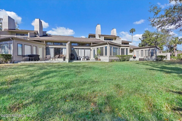 rear view of property with a lawn and a patio