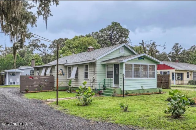 ranch-style house with a front lawn and a sunroom