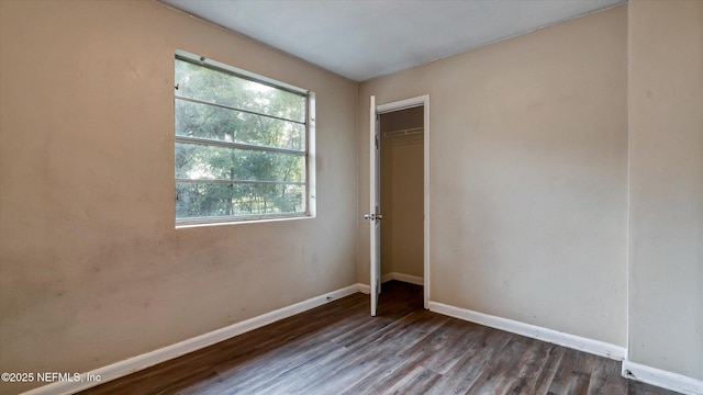 unfurnished bedroom with dark hardwood / wood-style flooring and a closet