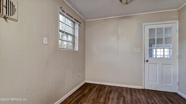 spare room featuring ornamental molding, dark hardwood / wood-style floors, and a textured ceiling