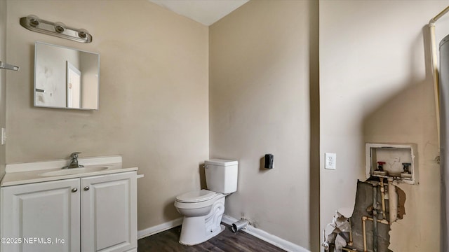 bathroom with vanity, toilet, and hardwood / wood-style floors