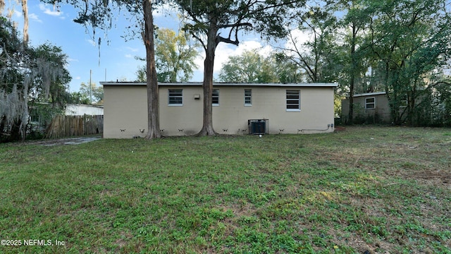 rear view of property featuring a yard and central AC