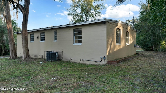 view of side of home featuring a yard and central air condition unit