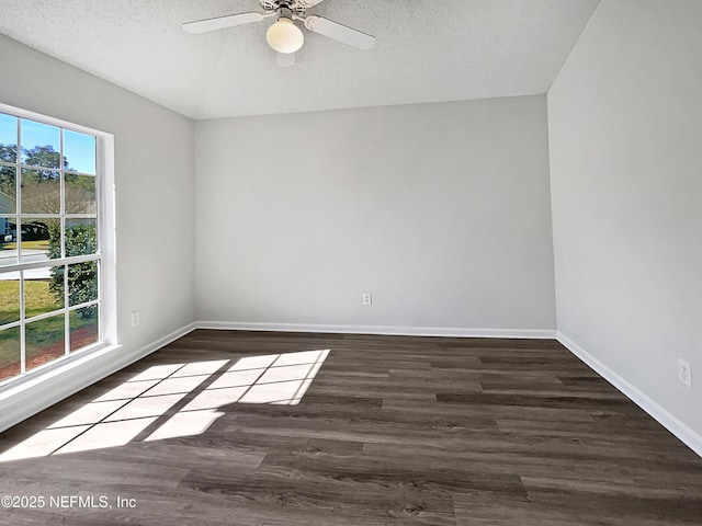 empty room with ceiling fan, dark hardwood / wood-style floors, and a textured ceiling