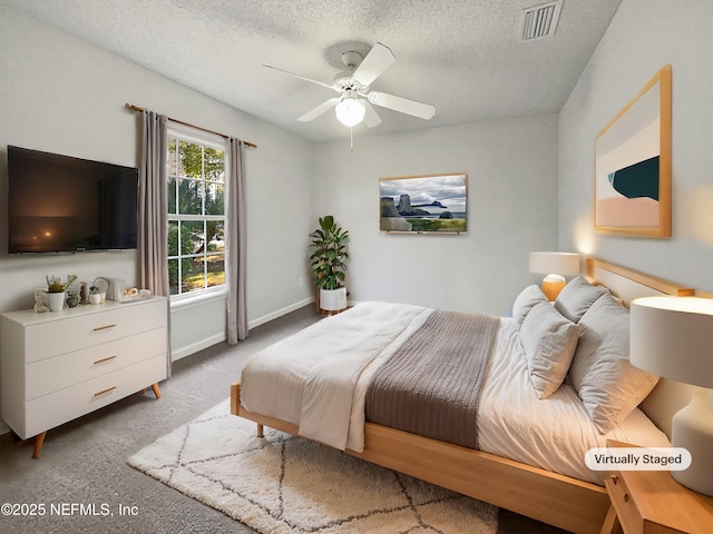 bedroom featuring ceiling fan, carpet floors, and a textured ceiling