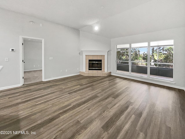 unfurnished living room with lofted ceiling, dark wood-type flooring, and a fireplace