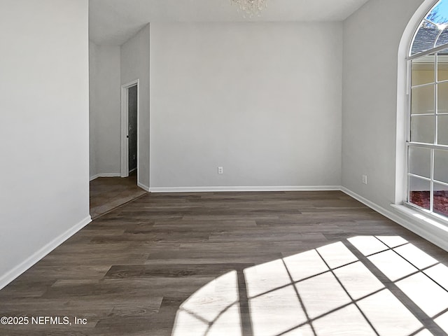 unfurnished room featuring plenty of natural light and dark hardwood / wood-style flooring