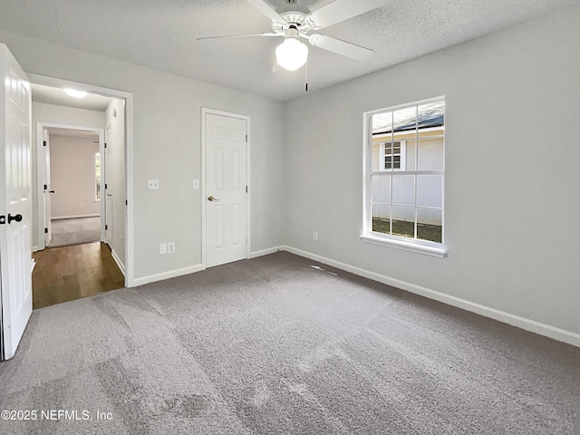 unfurnished bedroom with ceiling fan, carpet, and a textured ceiling