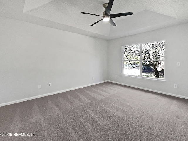 carpeted spare room with ceiling fan, a raised ceiling, and a textured ceiling