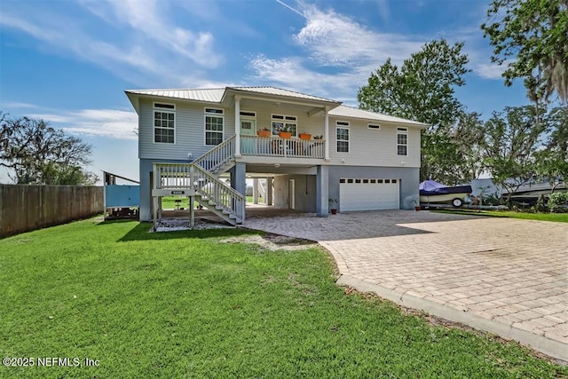 view of front facade featuring a garage, a front yard, and covered porch