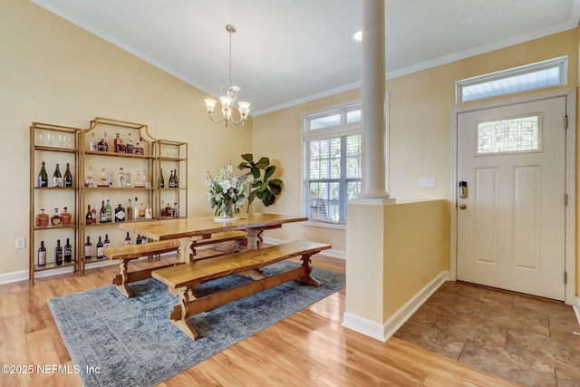 94202 Christopher Ln, Fernandina Beach, FL 32034 - dining space featuring an inviting chandelier, crown molding, ornate columns, and light wood-type flooring