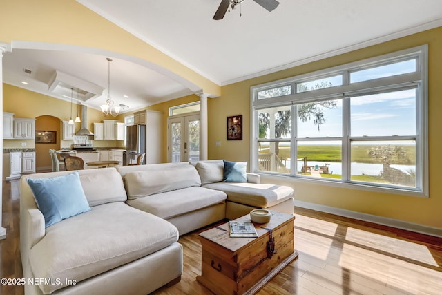 94202 Christopher Ln, Fernandina Beach, FL 32034 - living room with vaulted ceiling, ceiling fan with notable chandelier, decorative columns, a water view, and light wood-type flooring