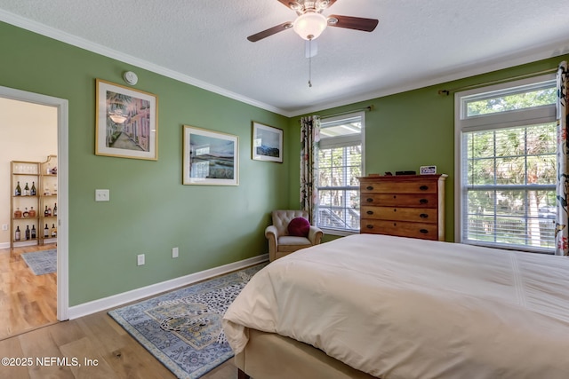 94202 Christopher Ln, Fernandina Beach, FL 32034 - bedroom with ceiling fan, crown molding, light hardwood / wood-style floors, and a textured ceiling