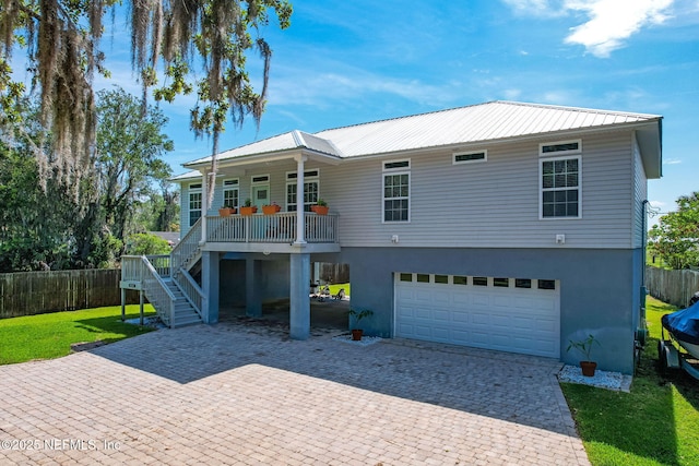 94202 Christopher Ln, Fernandina Beach, FL 32034 - rear view of house featuring a garage, covered porch, and a lawn