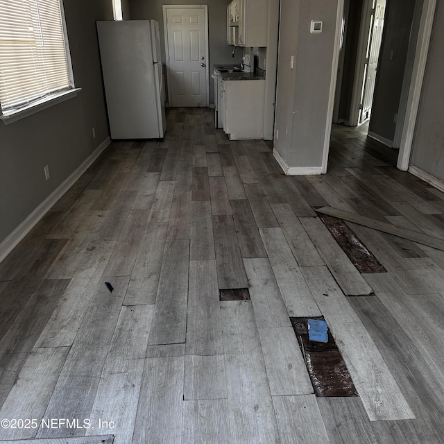 kitchen with wood-type flooring, white cabinets, and white refrigerator