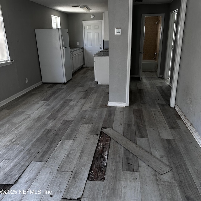 kitchen featuring hardwood / wood-style flooring, white cabinets, and white refrigerator