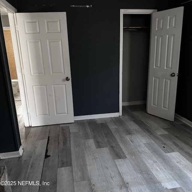 unfurnished bedroom with a closet and light wood-type flooring