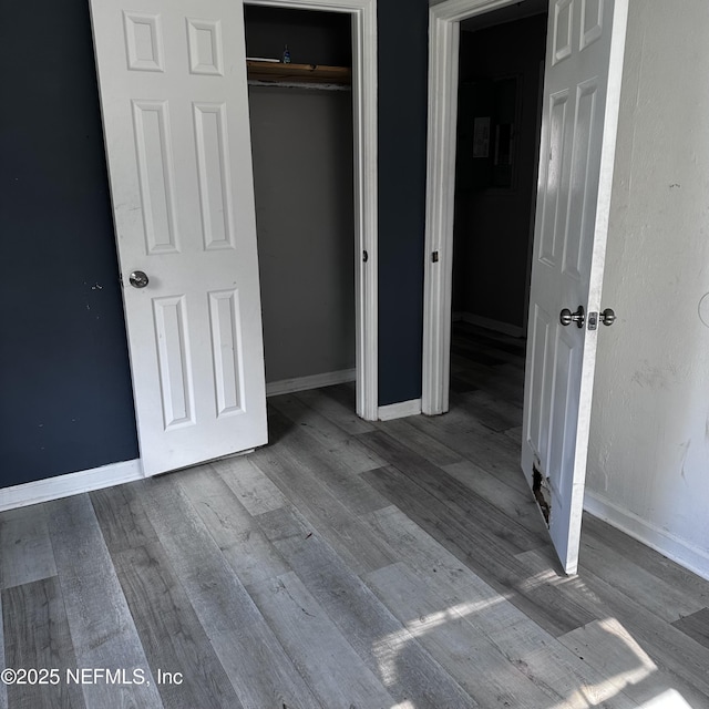 unfurnished bedroom featuring hardwood / wood-style floors and a closet