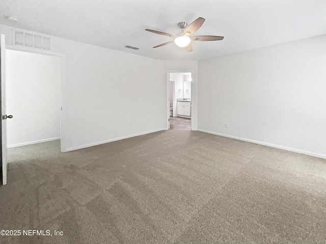 spare room with ceiling fan and dark colored carpet