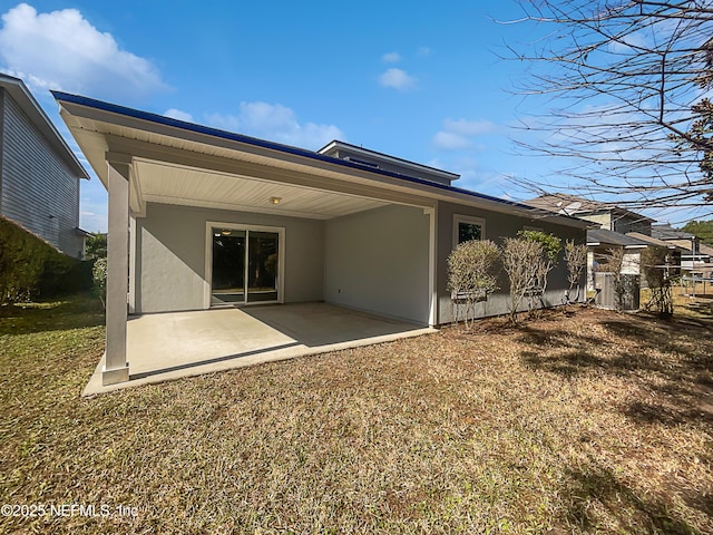 rear view of house with cooling unit, a patio, and a lawn