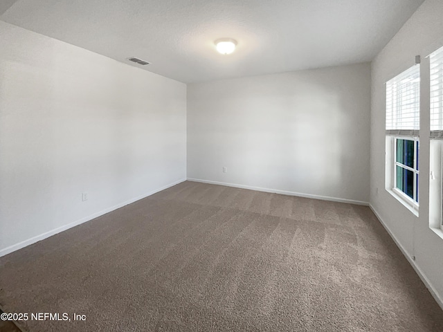 carpeted empty room featuring a textured ceiling