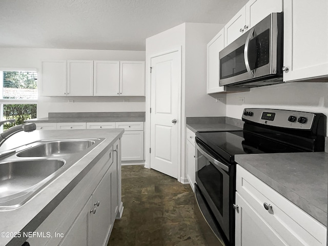 kitchen featuring appliances with stainless steel finishes, sink, and white cabinets