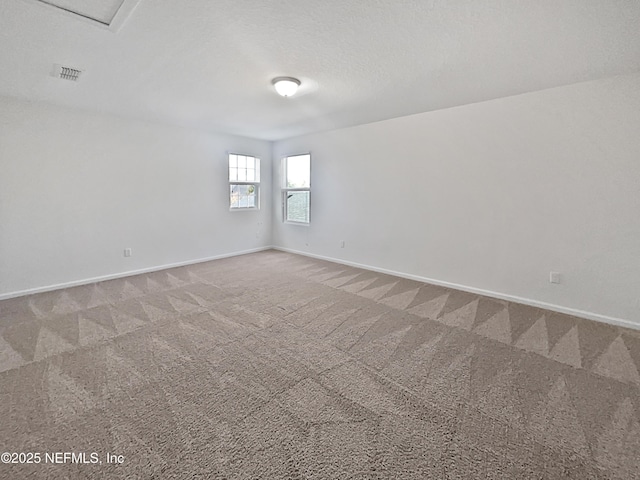 carpeted empty room with a textured ceiling