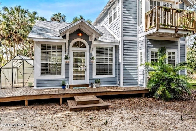 entrance to property featuring a shingled roof