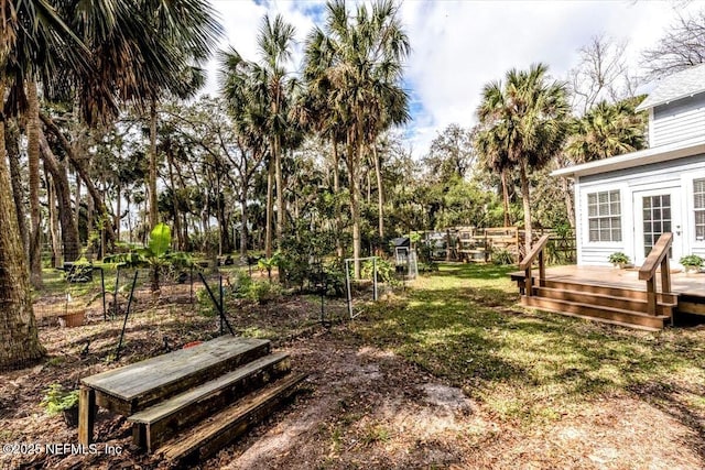 view of yard with fence, french doors, and a wooden deck