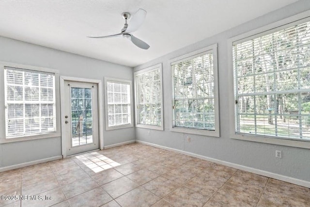 unfurnished sunroom featuring ceiling fan