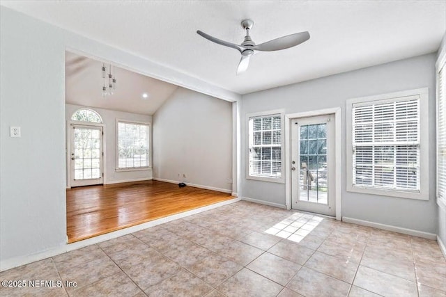 interior space featuring lofted ceiling, ceiling fan, baseboards, and tile patterned floors