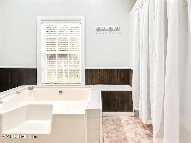 full bath featuring a garden tub and a sink