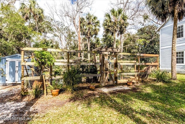 view of yard featuring an outbuilding, a storage shed, and fence