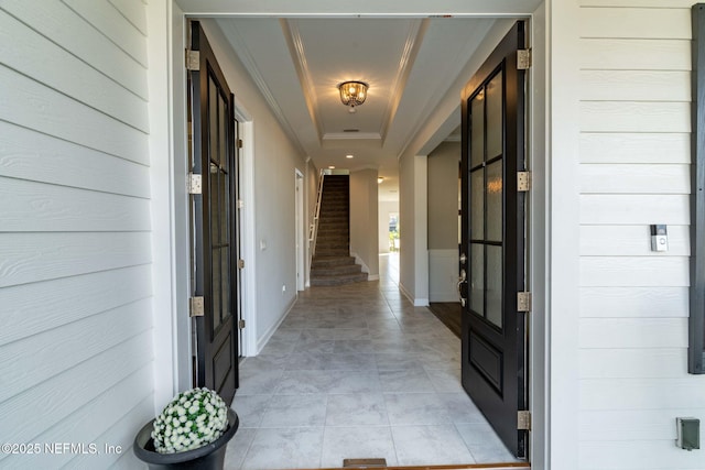 hall featuring a raised ceiling and light tile patterned floors