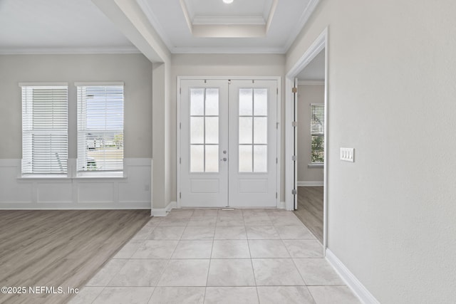 entryway with crown molding, light hardwood / wood-style flooring, and french doors