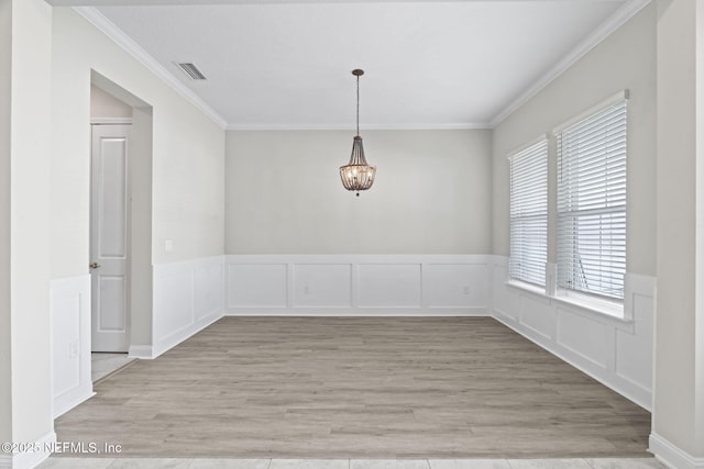 unfurnished dining area with ornamental molding and light wood-type flooring