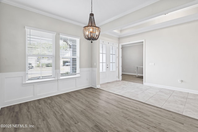 unfurnished dining area featuring crown molding, a notable chandelier, and light hardwood / wood-style floors