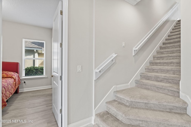 staircase with hardwood / wood-style floors