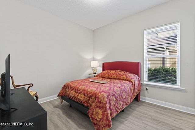 bedroom featuring wood-type flooring and a textured ceiling